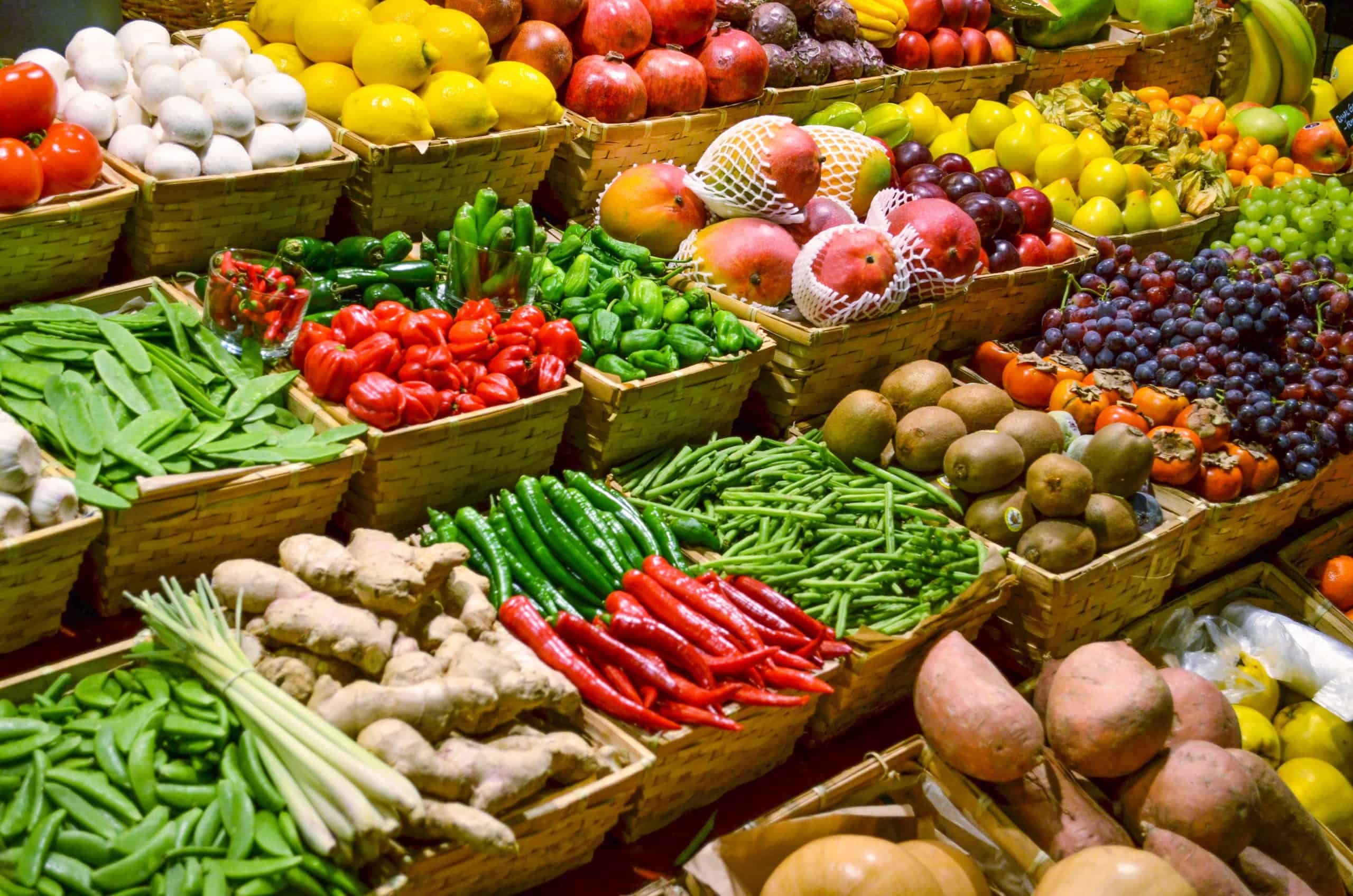 Produce market with various colorful fresh fruits and vegetables.