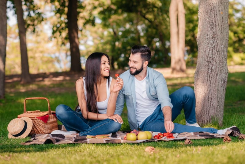 Man and woman having a picnic together outside.
